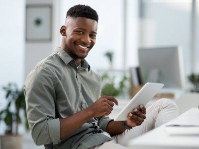 The stats are looking good. Shot of a young businessman working on a computer in an office.